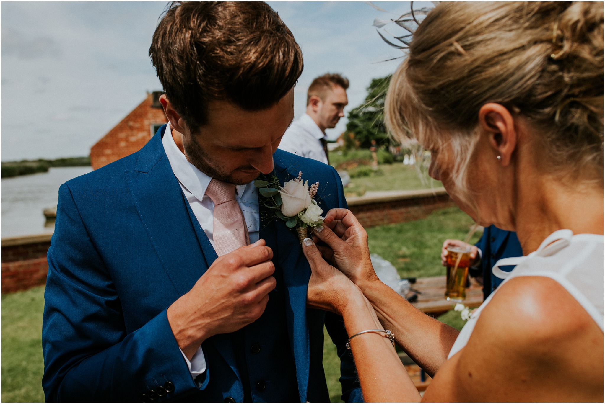 groom getting buttonhole put on at the ferrry inn in stokesby