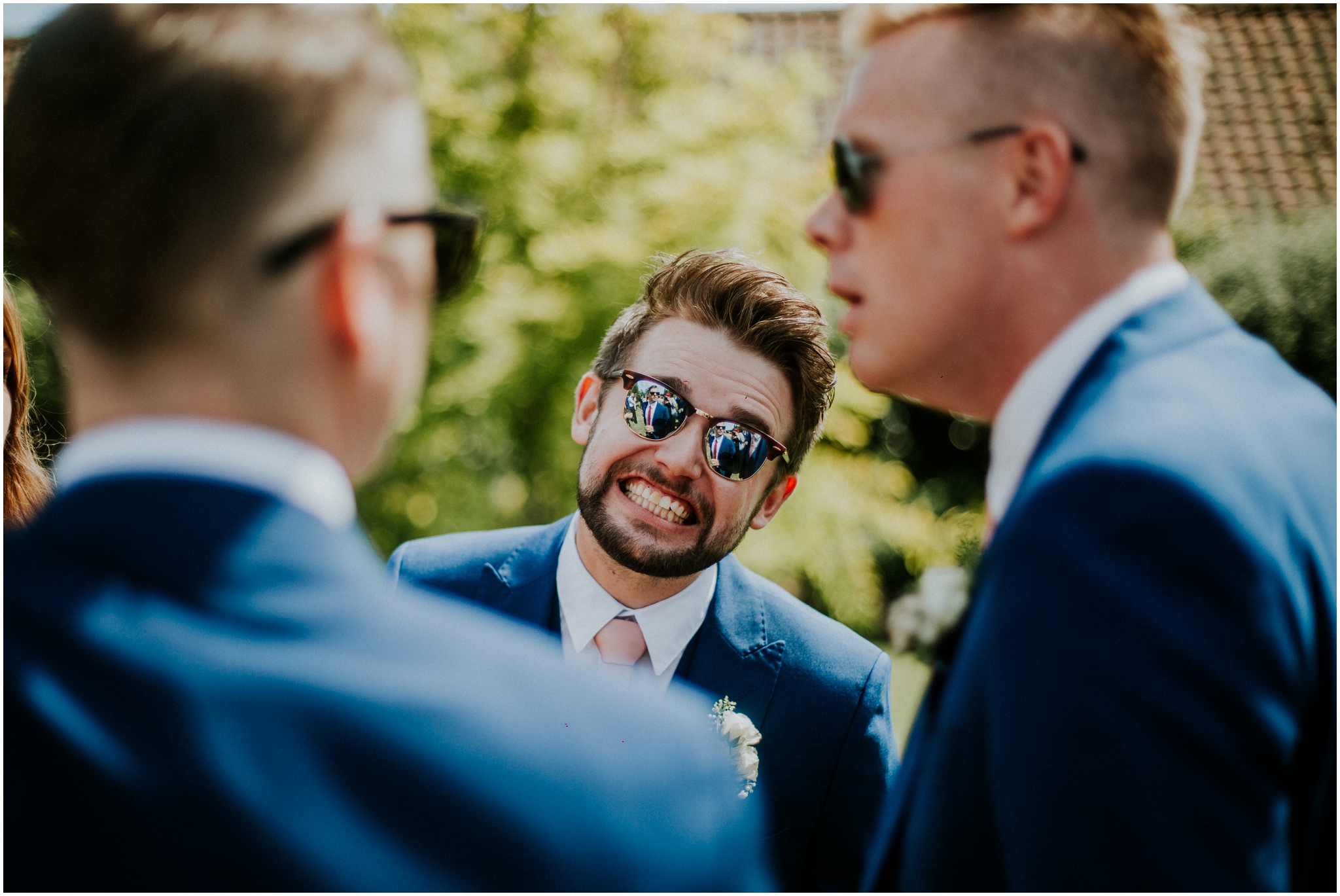 groomsman grinning wearing sunglasses