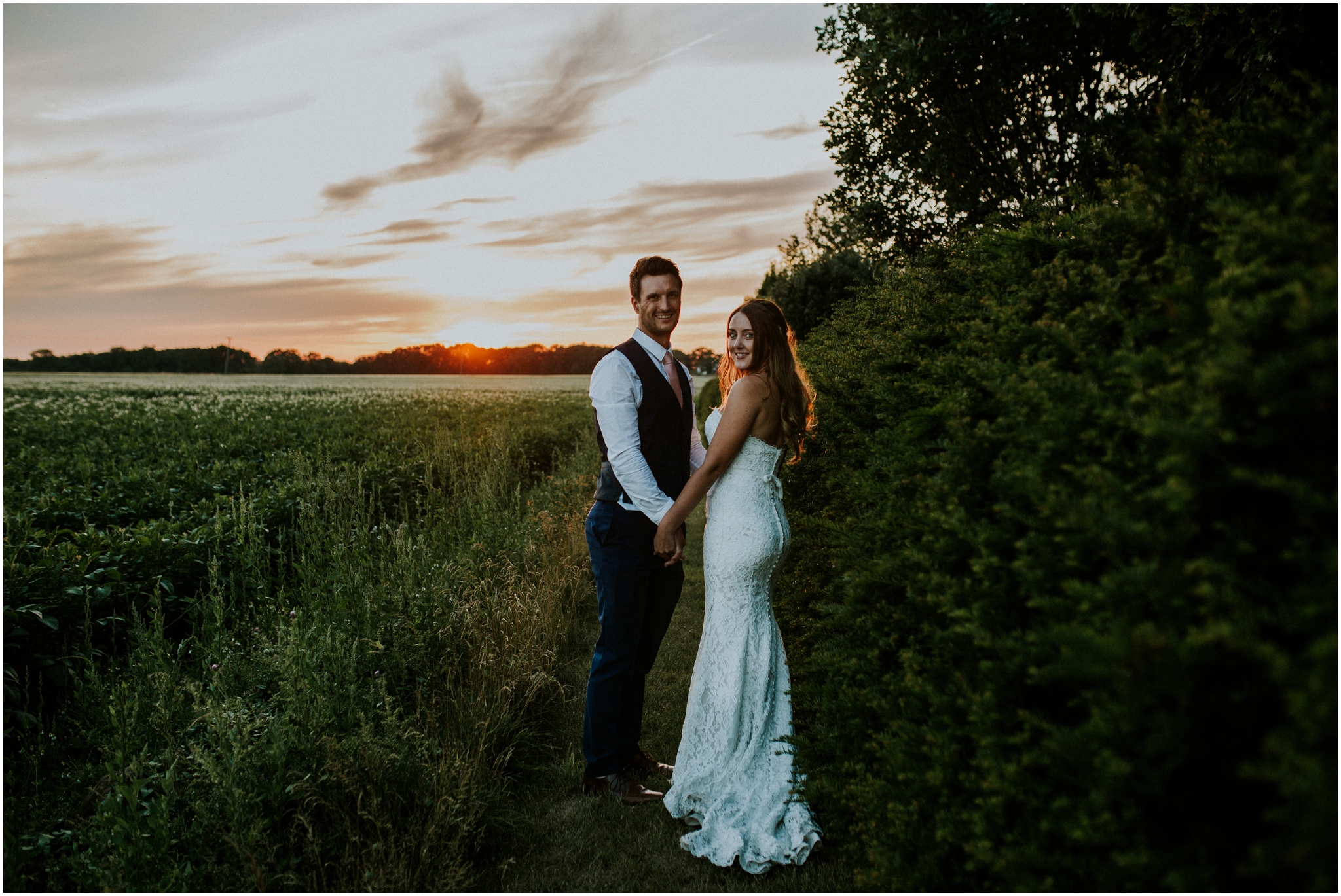 bride and groom holding hands during sunset
