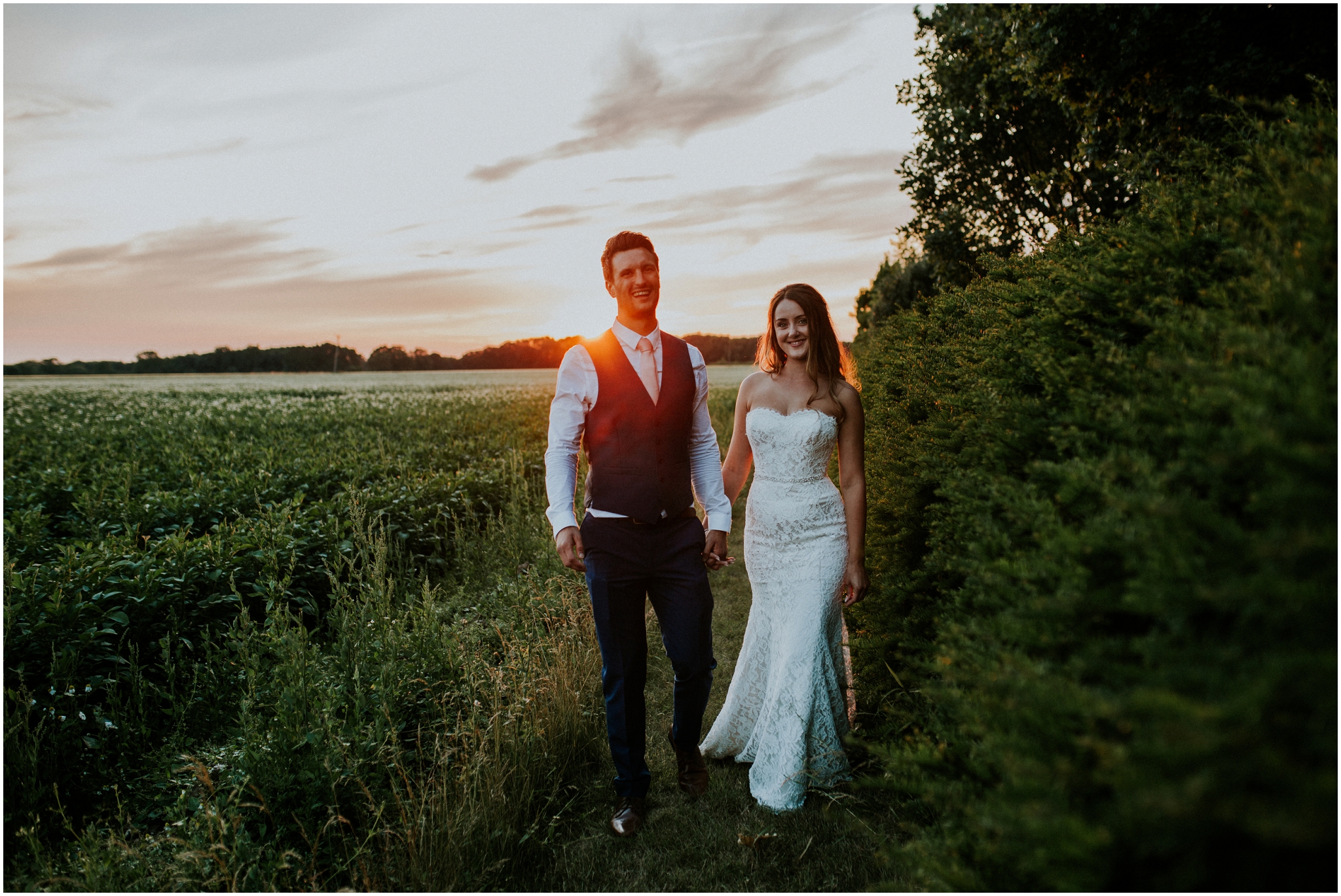 bride and groom holding hands during sunset