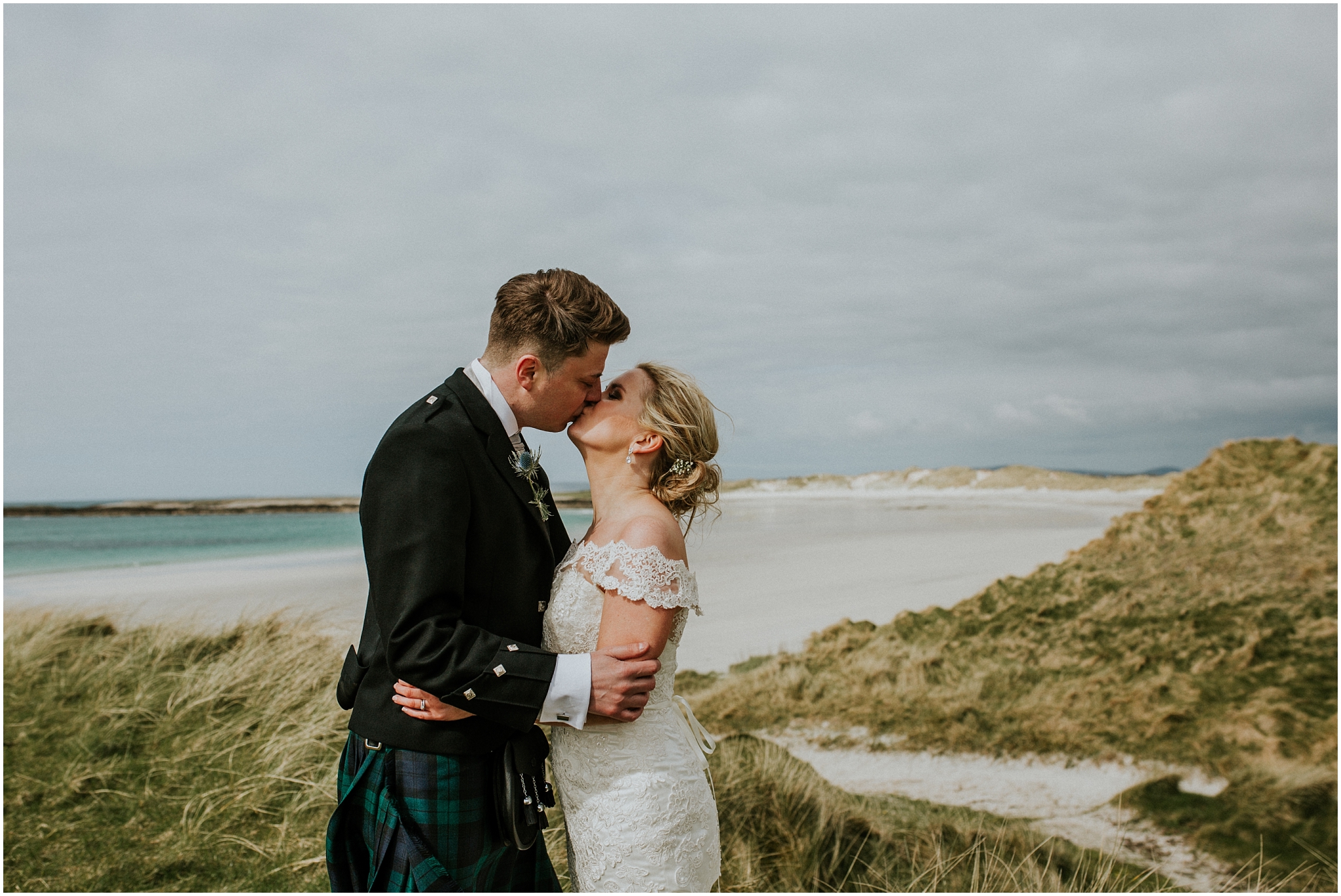bride and groom kissing on the dunes