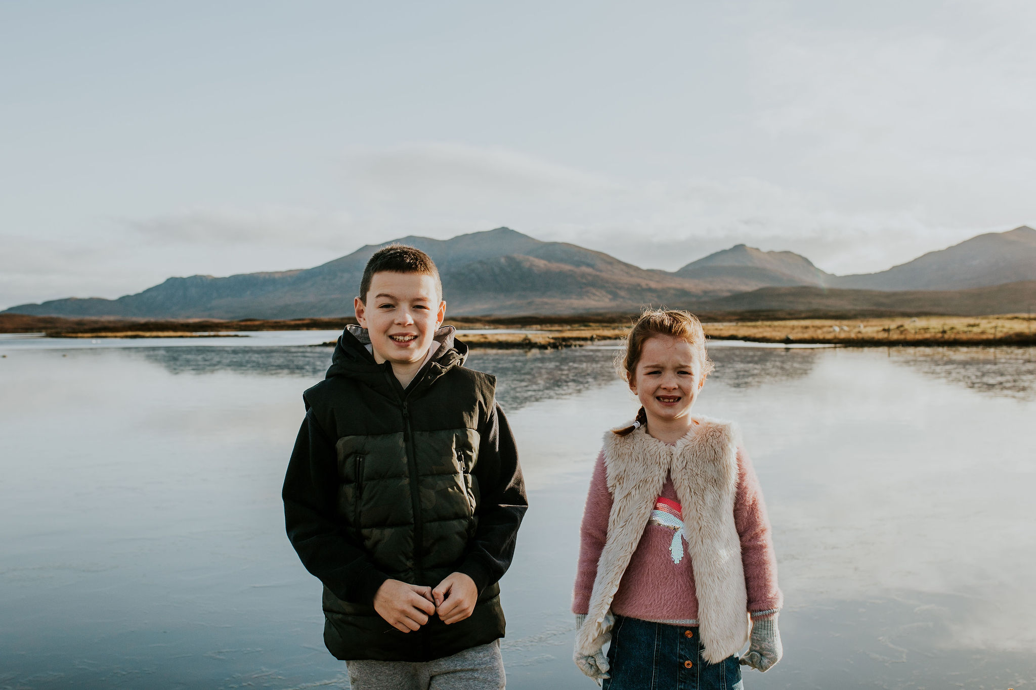 Brother and Sister standing in front of a frozen loch on the Isle of South Uist