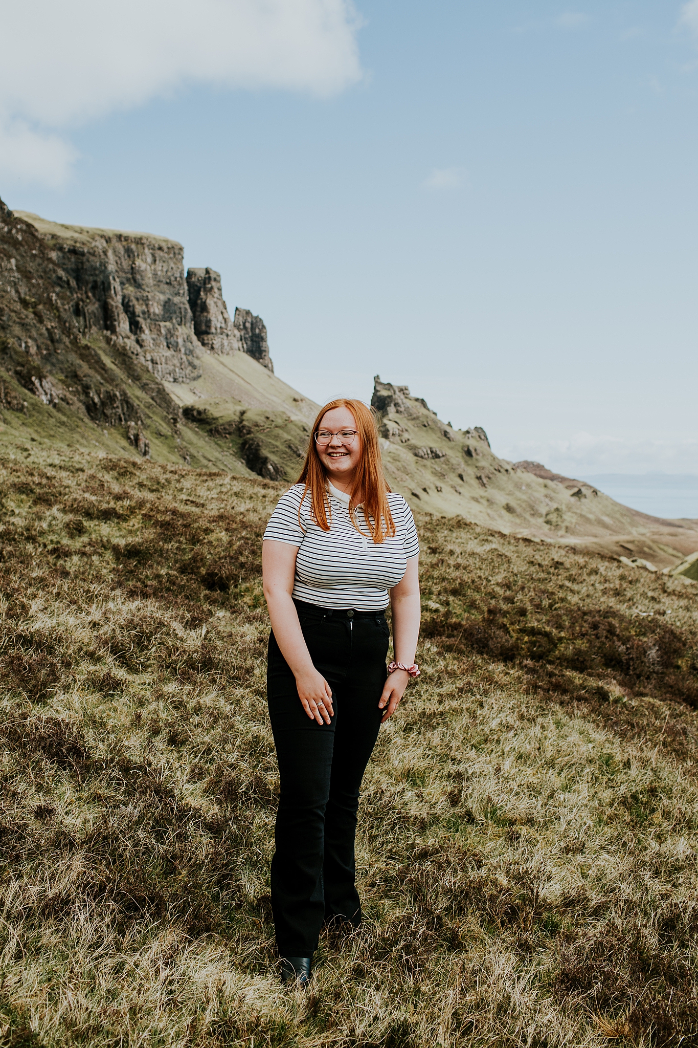 Young red head girl laughing at her family at the quiraing on the isle of skye
